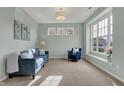Cozy living room with a large window, blue sofa and chair, and neutral carpet at 4546 Creighton Ln, Indianapolis, IN 46237