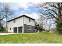 Home featuring a two-car garage, complimented by a green lawn and mature trees at 5302 E 46Th St, Indianapolis, IN 46226
