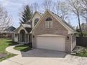 A view of a brick home featuring an attached garage and well-maintained lawn at 5461 Steven Dr, Greenwood, IN 46142