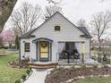 Charming home featuring a covered porch, colorful accents, and well-maintained landscaping at 57 Worman St, Indianapolis, IN 46227
