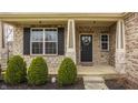 Charming front porch with stone accents, decorative wreath, and well-maintained landscaping at 5869 Belchamp Dr, Noblesville, IN 46062