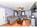Inviting living room features hardwood floors, a ceiling fan, a stone fireplace, and ample seating at 590 N 17Th St, Noblesville, IN 46060