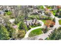 Aerial view of an estate home surrounded by lush greenery, mature trees, and a circular driveway at 7545 Chablis Cir, Indianapolis, IN 46278