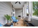 Relaxing screened porch with wood floors, a ceiling fan, comfortable seating, and white sheer curtains at 7638 Beekman Ter, Zionsville, IN 46077