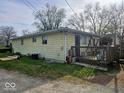 Rear view of the property featuring a small deck and a well kept yard at 8412 E 47Th St, Indianapolis, IN 46226
