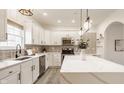Modern kitchen features white cabinets, stainless steel appliances, and expansive island with stylish pendant lighting at 861 S Park Trail Dr, Carmel, IN 46032