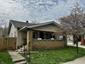 Charming single-story home with a brick porch and a well-maintained front yard, complemented by a mature tree at 1020 N Colorado Ave, Indianapolis, IN 46201