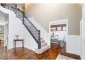 Entryway foyer with staircase, wainscoting, and hardwood floors leading to dining room at 11410 Sea Side Dr, Fishers, IN 46040
