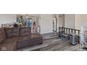 Another view of the living room with wood-look floors and a comfortable brown sofa at 1206 Rosengarten Dr, Greenwood, IN 46142