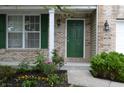 Charming brick home featuring a green front door, well-kept lawn, and lovely landscaping with colorful flowers at 12326 River Valley Dr, Fishers, IN 46037