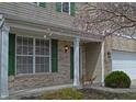 Charming covered front porch and door with brick and siding, and flowering tree at 12326 River Valley Dr, Fishers, IN 46037