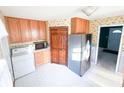 Functional kitchen with wood cabinetry, stainless steel fridge, and adjacent laundry area at 126 Mercator Dr, Greenwood, IN 46143