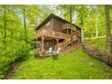 View of a spacious backyard with a wooden deck, fire pit, and wooden stairs leading to the house at 13306 W 50 S, Columbus, IN 47201