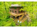 Beautiful view of a two-story house with a large wooden deck and lush trees surrounding it at 13306 W 50 S, Columbus, IN 47201