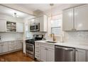 Well-lit kitchen featuring white cabinets, stainless steel appliances, and hardwood floors at 171 W 44Th St, Indianapolis, IN 46208