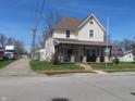 Charming two-story home featuring a cozy front porch and well-maintained front yard at 210 E Monroe St, Alexandria, IN 46001
