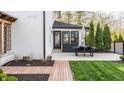 Well-manicured backyard featuring a brick patio with outdoor seating, lush green lawn, and elegant landscaping at 222 E 71St St, Indianapolis, IN 46220