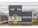 Modern two-story building with gray siding and yellow door offering a contemporary architectural design at 2329 Shelby St, Indianapolis, IN 46203