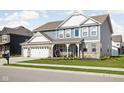 Charming two-story home featuring a landscaped front yard, porch with seating, and a two-car attached garage at 2536 Maricopa Blvd, Whitestown, IN 46075