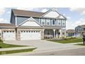 Charming two-story home featuring a landscaped front yard, covered porch with seating, and a two-car attached garage at 2536 Maricopa Blvd, Whitestown, IN 46075
