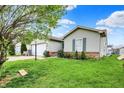 Side view of a cozy home showing the lawn, partial garage and garden bed at 3110 S Temple Ave, Indianapolis, IN 46237