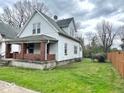 The side view of a traditional two-story home with an inviting brick porch and quaint windows at 359 W 26Th St, Indianapolis, IN 46208
