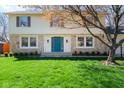 Charming home with a stone facade, a bright teal front door, and a lush green lawn at 3738 Barrington Dr, Carmel, IN 46033