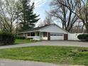 Ranch style home with attached garage, brick accents, white siding, and a quaint, covered porch at 4290 Manning Rd, Indianapolis, IN 46228