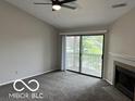 Inviting living room featuring fireplace, vaulted ceiling, and sliding glass doors to balcony at 4311 Village Parkway W Cir # 6, Indianapolis, IN 46254