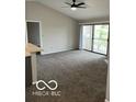 Living room with neutral tones, vaulted ceiling, and slider to balcony with outdoor views at 4311 Village Parkway W Cir # 6, Indianapolis, IN 46254
