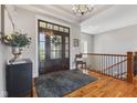 Inviting foyer with hardwood floors, a decorative rug, and a dark wood front door with glass panels at 5348 Ashby Ct, Greenwood, IN 46143