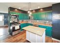 Well-equipped kitchen with green cabinetry, stainless steel appliances, an island, and modern fixtures at 575 Everling Dr, Morgantown, IN 46160
