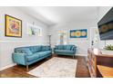 Comfortable living room featuring blue sofas, hardwood floors, and a cheerful, patterned rug at 5817 Beechwood Ave, Indianapolis, IN 46219