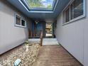 Inviting entrance featuring a skylight, stone garden, wooden deck, and a blue front door at 6827 S 500 W, Trafalgar, IN 46181