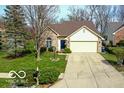 Inviting home with lush lawn, mature trees, and a driveway leading to an attached two-car garage at 701 Danver Ln, Beech Grove, IN 46107