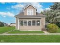 Inviting home with a manicured lawn, mature tree, and cozy front porch at 702 S Fanning St, Sheridan, IN 46069