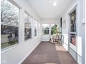 Bright sunroom with multiple windows, neutral decor, and cozy seating area at 702 S Fanning St, Sheridan, IN 46069