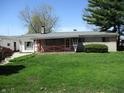 Charming single-story home with a cozy front porch and lush green lawn at 7402 Alice Ave, Indianapolis, IN 46219