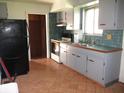 Functional kitchen with tile flooring, tile backsplash, and light grey cabinetry at 7402 Alice Ave, Indianapolis, IN 46219