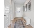 Inviting entryway with a decorative rug, bench, and natural light streaming through the front door at 8673 Laurelton Pl, Brownsburg, IN 46112
