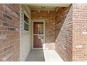 Exterior view of the home's entrance, featuring a brick wall and a storm door at 9526 Colony Pointe E Dr, Indianapolis, IN 46250