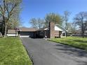 Well-maintained single-story brick home with an attached garage and a long driveway at 1020 Cottonwood Dr, Columbus, IN 47203