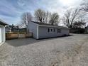 Side view of the house featuring a wooden deck and gravel landscaping at 103 N Nebraska St, North Salem, IN 46165