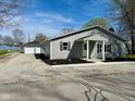 One-story home with a detached two-car garage, gray siding, black shutters, and a gravel driveway at 103 N Nebraska St, North Salem, IN 46165