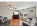 Comfortable living room with hardwood floors, a ceiling fan, and large windows at 10881 August Dr, Ingalls, IN 46048