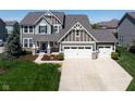 Inviting two-story home with a gray facade, manicured lawn, and a spacious driveway leading to a two-car garage at 11014 Woodpark Dr, Noblesville, IN 46060