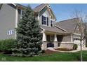 Attractive two-story home with a welcoming front porch, lush landscaping, and a well-maintained lawn at 11014 Woodpark Dr, Noblesville, IN 46060