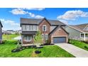 Beautiful two-story home with lush front lawn, charming covered porch and attached garage in a Gathering friendly community at 132 Oakhurst Way, Westfield, IN 46074