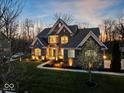 Charming two-story brick home with manicured lawn, mature trees, professional landscaping, and exterior lighting at 13314 Lansbury Ln, Fishers, IN 46037