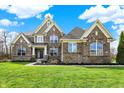 A beautiful two-story brick home with a well-manicured lawn, professional landscaping, and great curb appeal at 13314 Lansbury Ln, Fishers, IN 46037